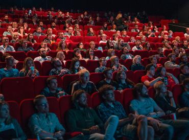 An image of people sitting in a full cinema