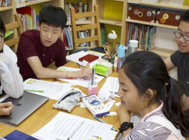LAMDA Exams learners sit around a table in a library
