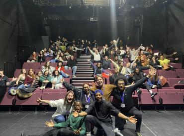 An auditorium of people pose for a photo with LAMDA staff, students and graduates at the Birmingham REP during a Pathways hub open day 