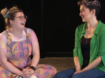 Photo of two LAMDA alumni, Danielle Phillips and Lizzie Schenk, in conversation on the Orange Tree Theatre stage.