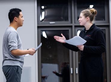 Two LAMDA short course participants holding scripts in a rehearsal room