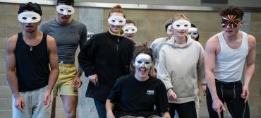A group of students wearing masks, during rehearsals for Much Ado About Nothing