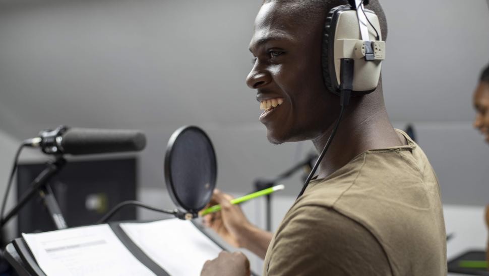 Smiling student in recording booth with headphones