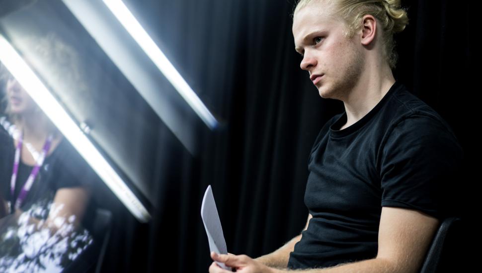 Man sitting with script, light strips in the background
