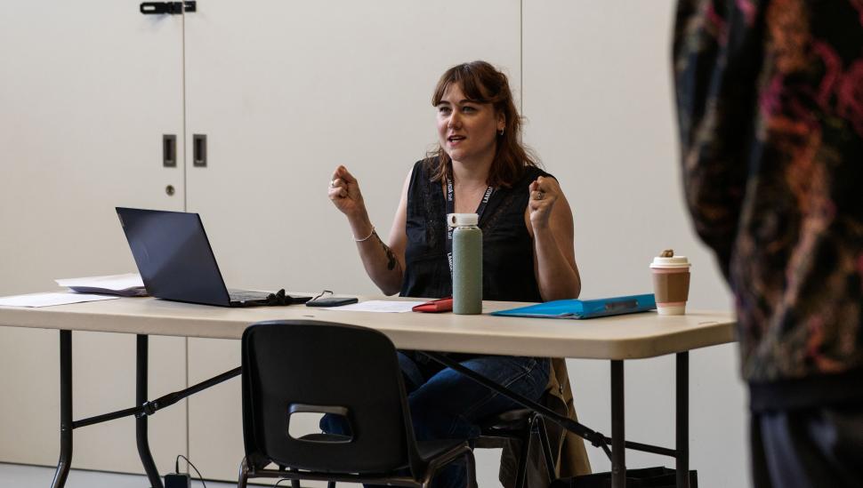 A LAMDA tutor with a laptop at a desk 