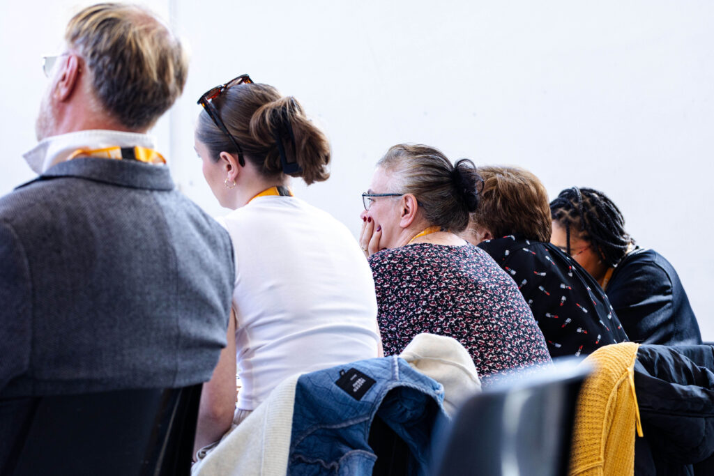 The backs of a group of 5 teachers as they sit in a line.