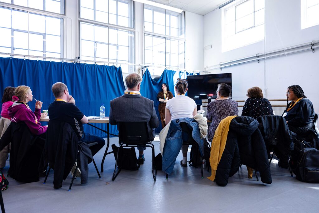 A group of teachers watching a practitioner teach a course