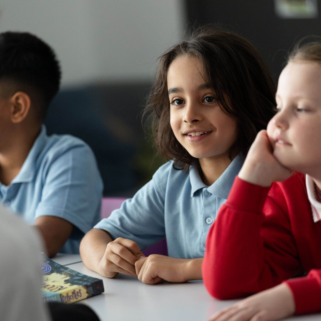Three learners sit in class together