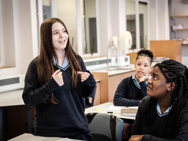 A learner stands up in class to deliver a speech