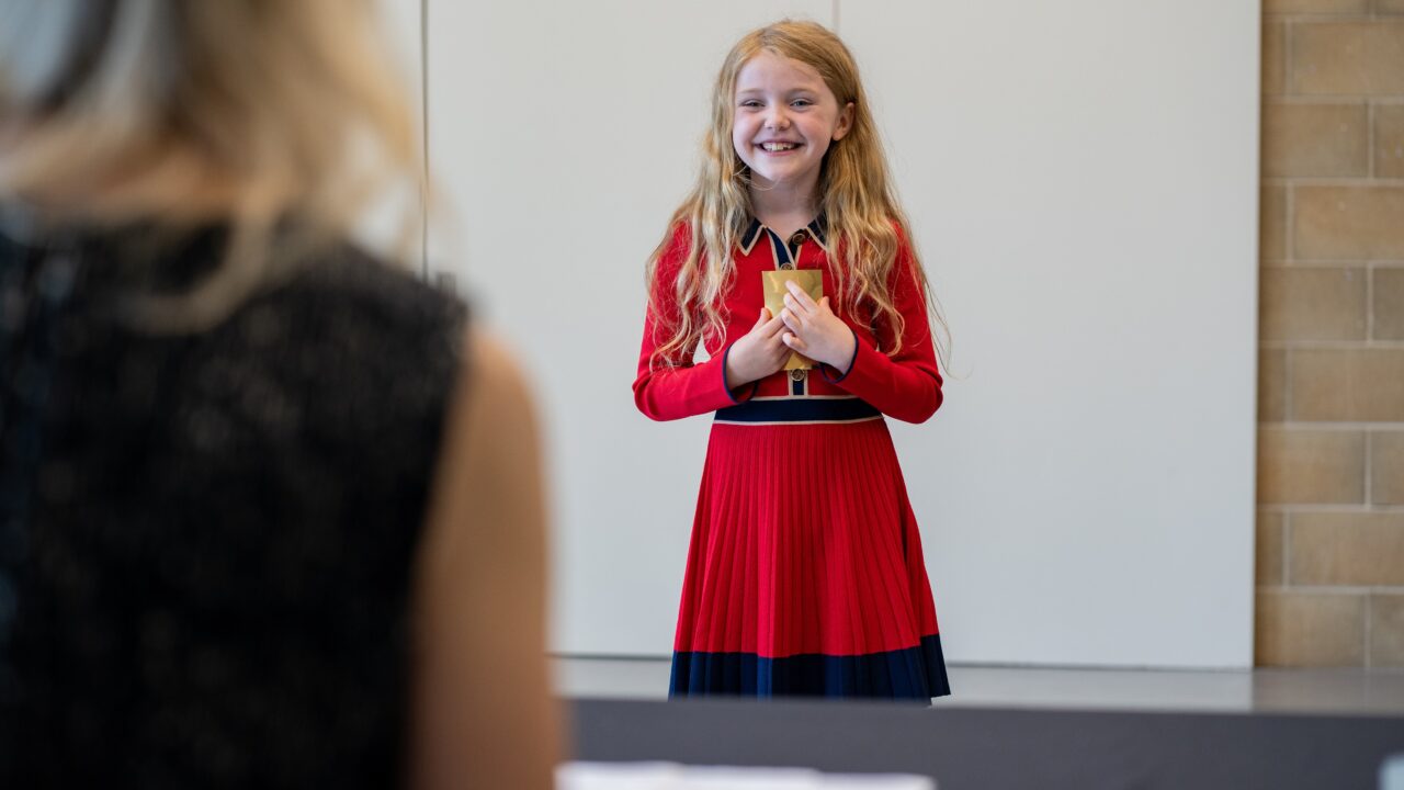 A learner holds a prop during a performance