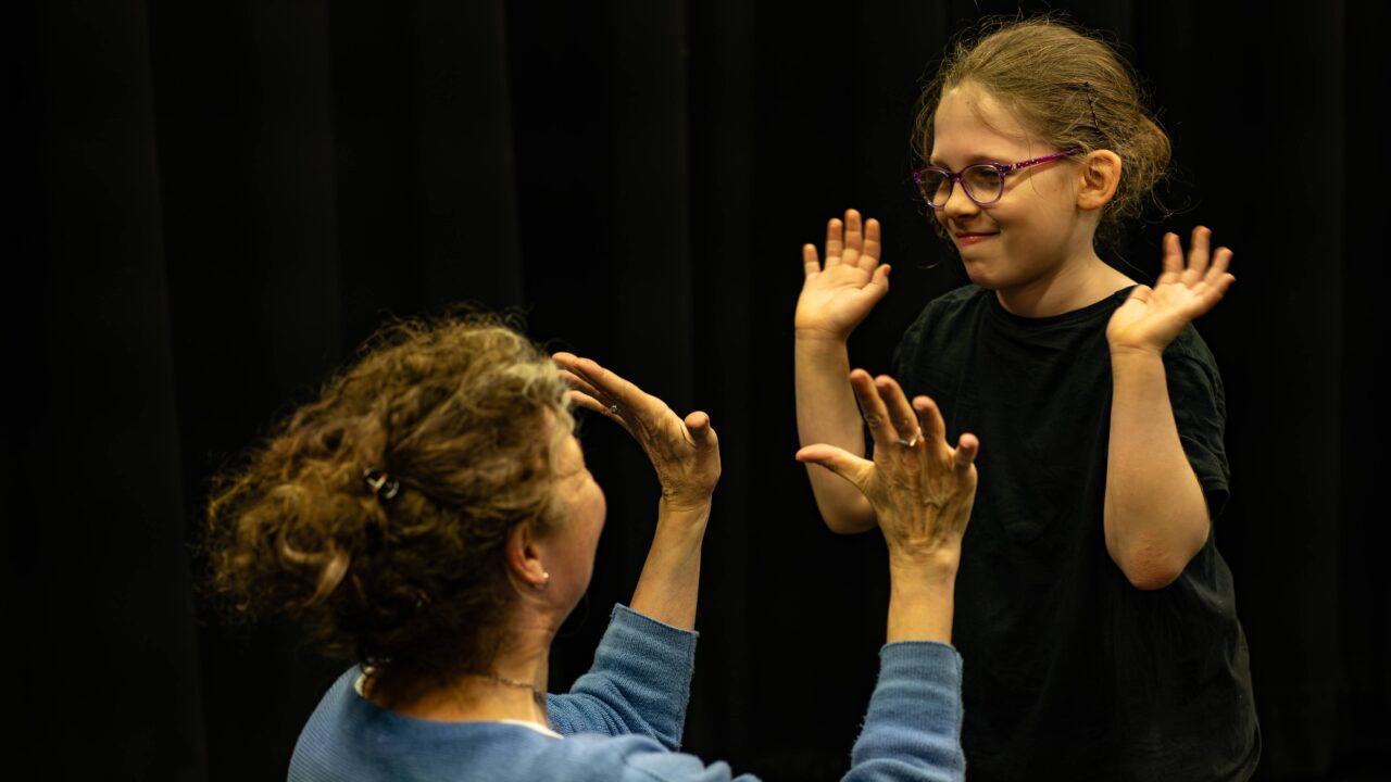A learner and teacher high five during a lesson.