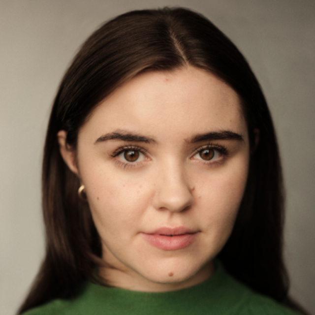 Close-up portrait of a young woman with dark hair, wearing a green top, looking directly at the camera