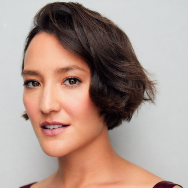 Portrait of a woman with short brown hair, smiling slightly at the camera