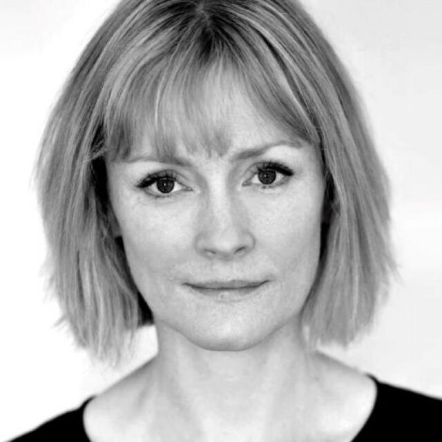 Black and white portrait of a woman with a bob haircut and fringe, looking directly at the camera