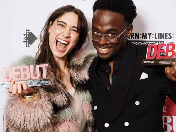 Two winners laughing and holding their Stage Debut Awards trophies at the ceremony