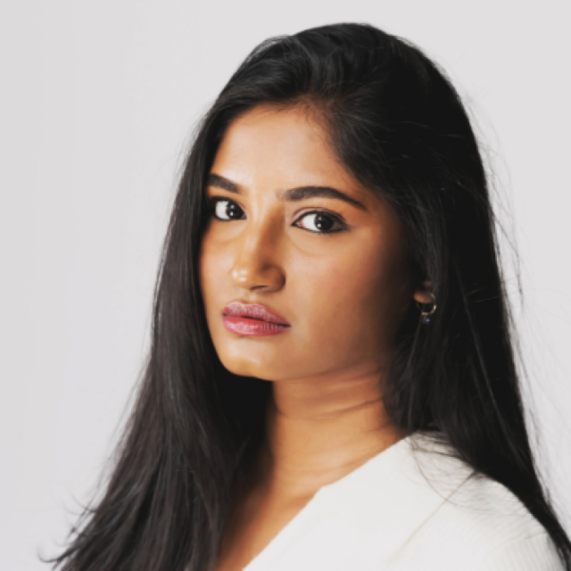 Woman with long dark hair looking directly at the camera with a serious expression