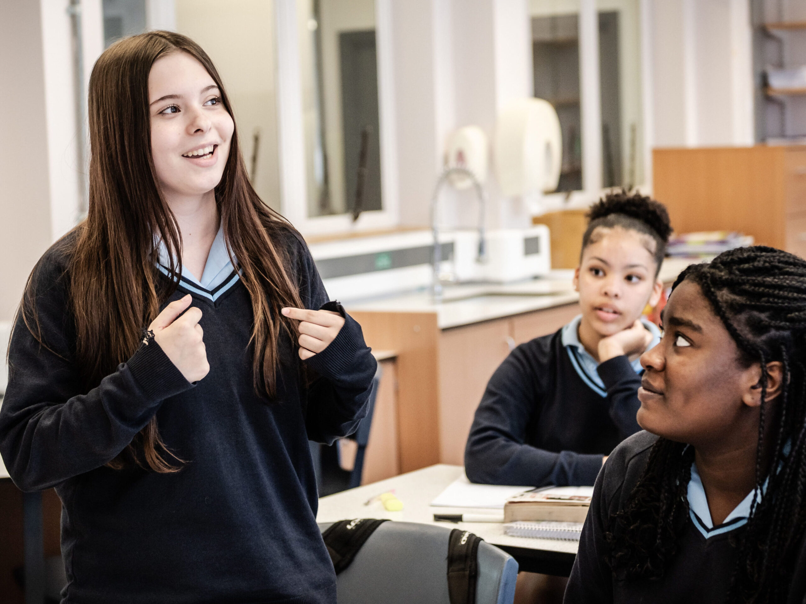 A learner stands up to present to the class