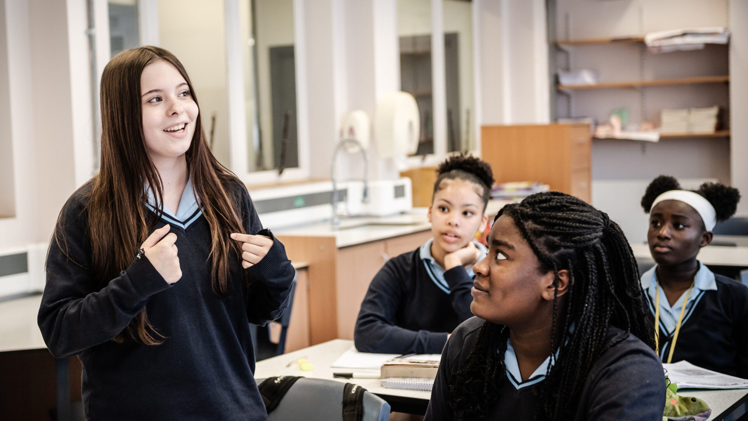 A learner stands up to present to the class