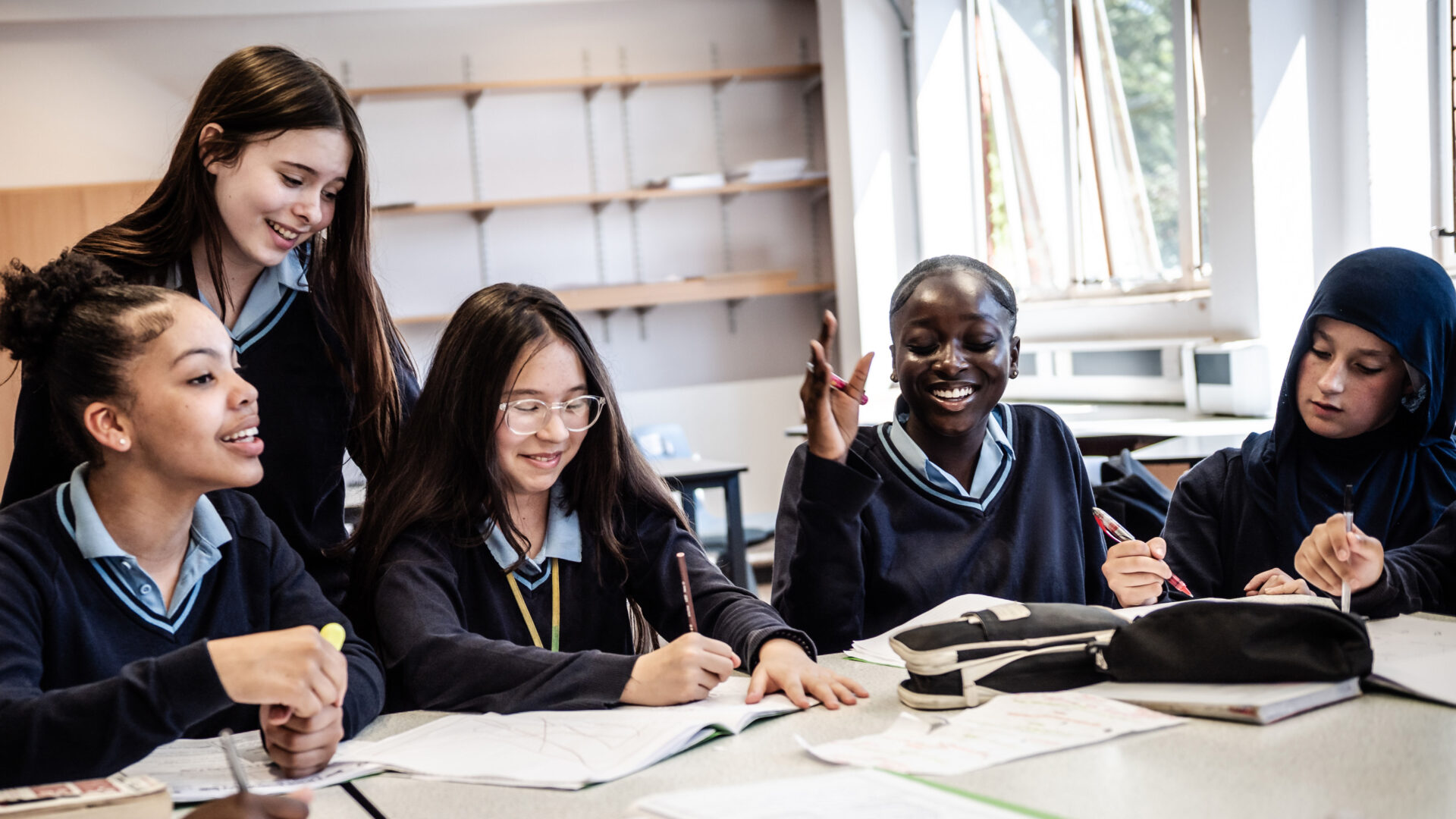 A group of learners work together at their desks