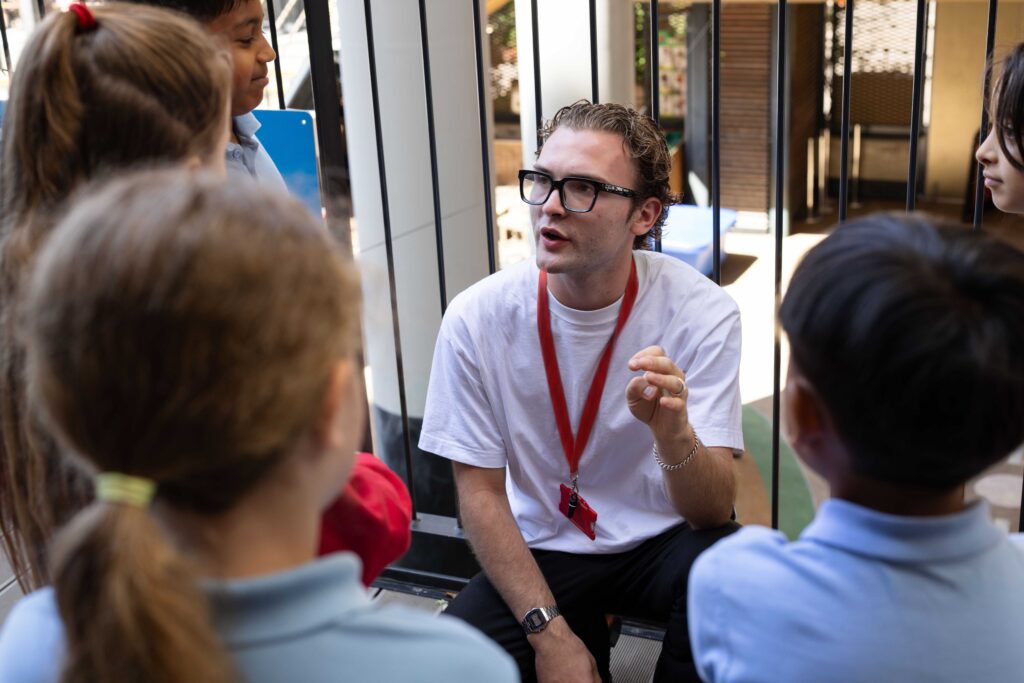 A teacher speaks to a group of learners during a lesson