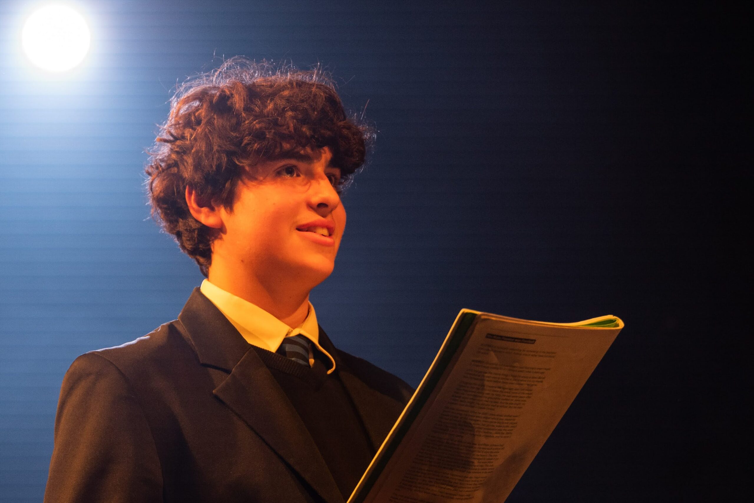 A learner holds a script during a lesson