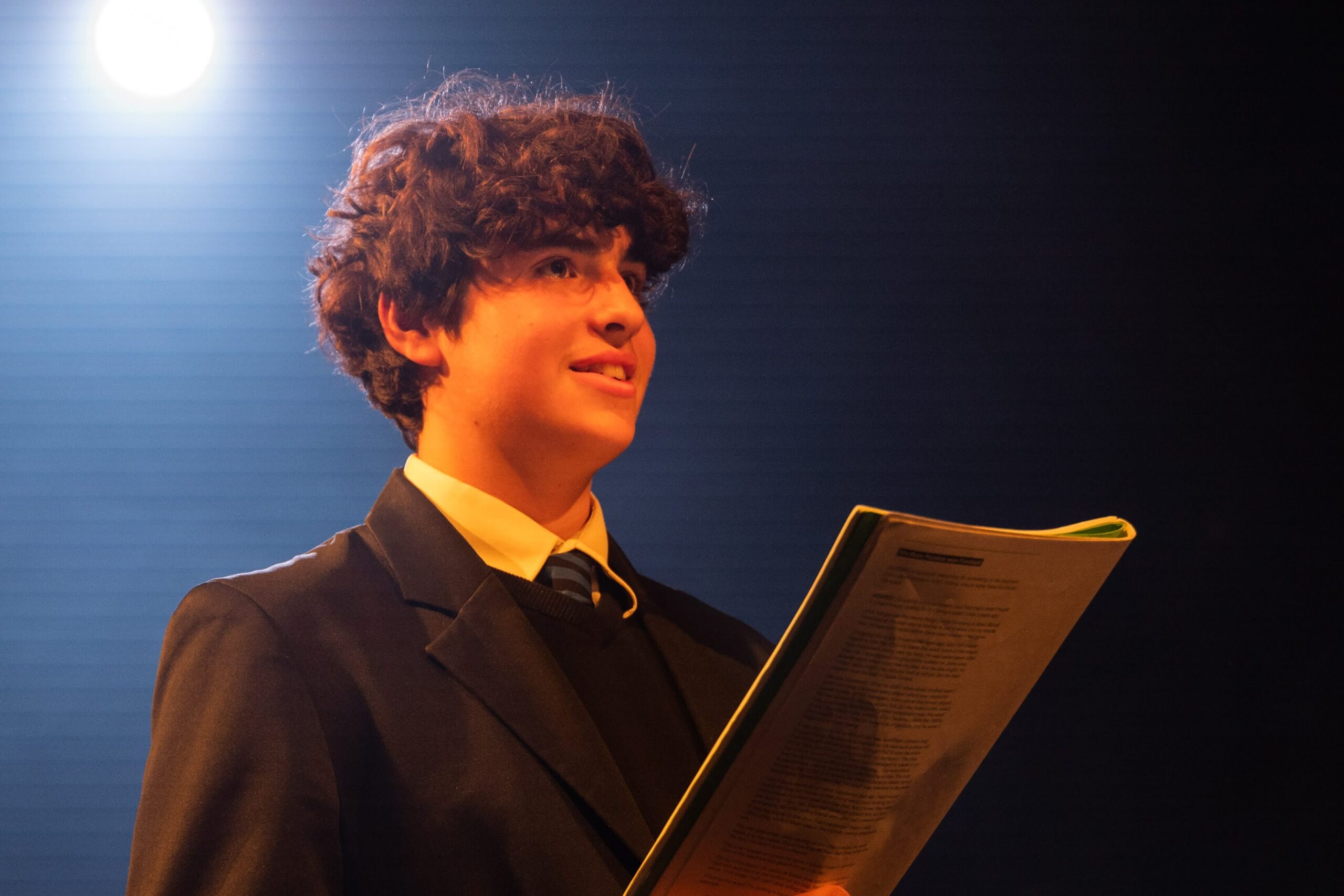 A learner holds a script during a lesson