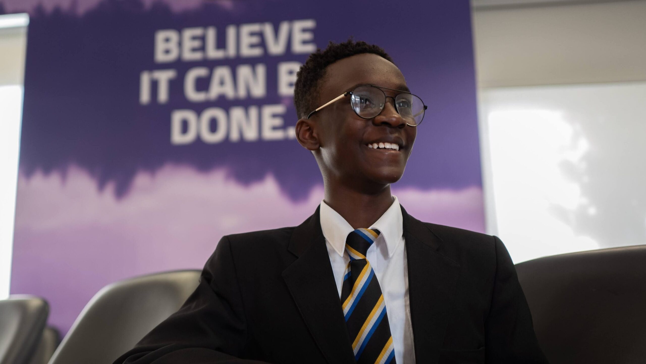 A learner sits at a desk in a classroom
