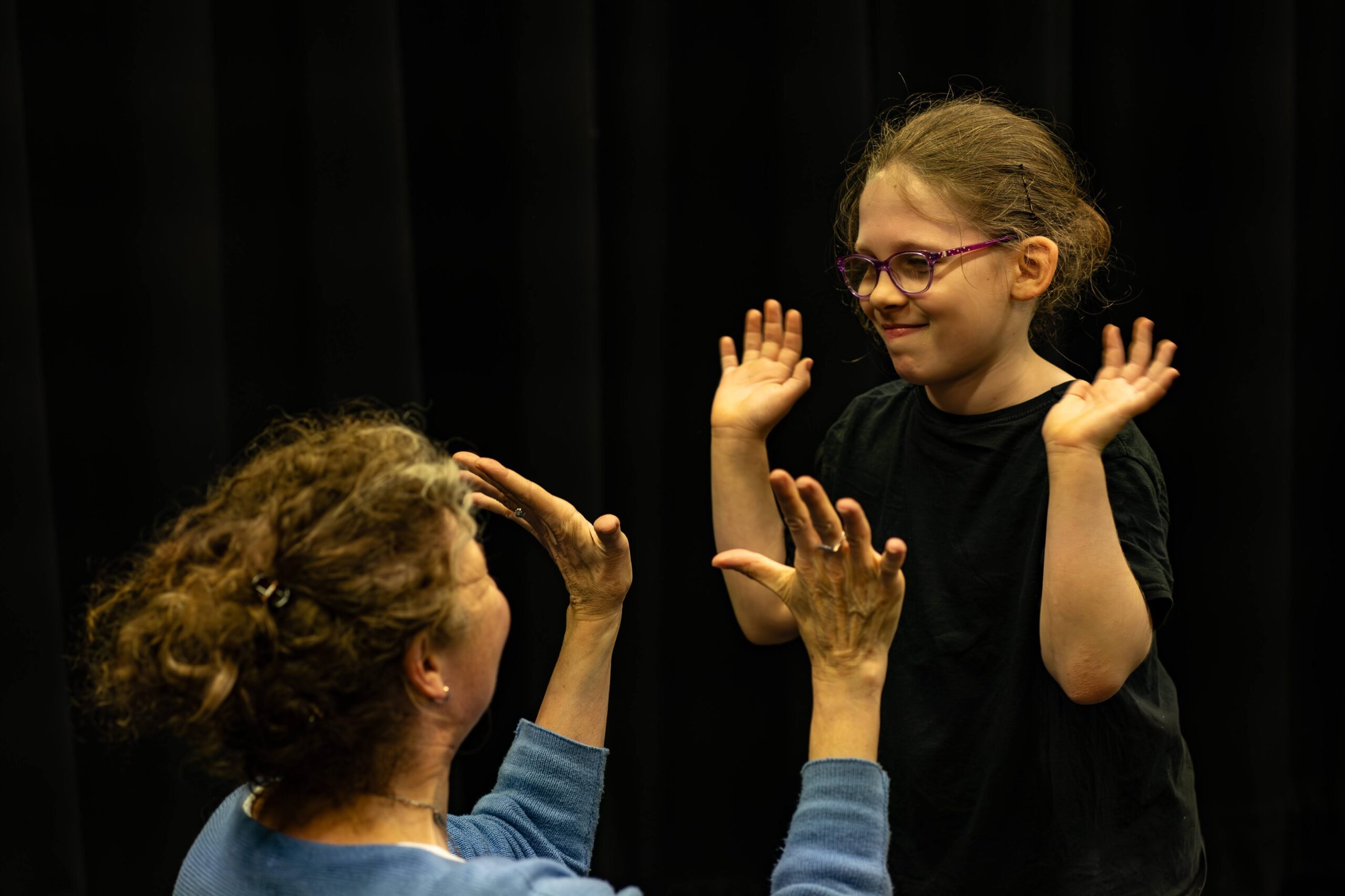 A learner and teacher high five during a lesson.