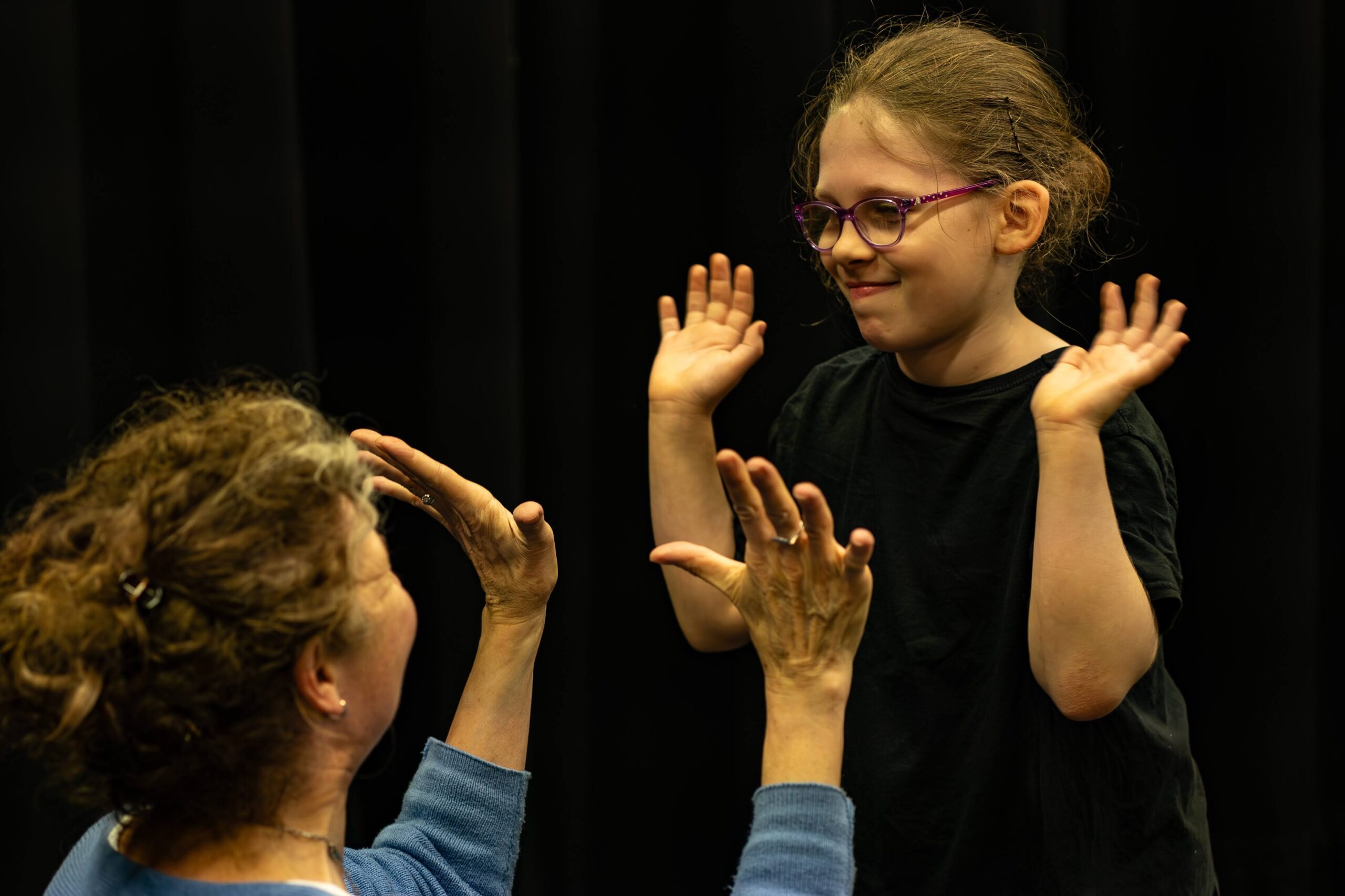 A learner and teacher high five during a lesson.