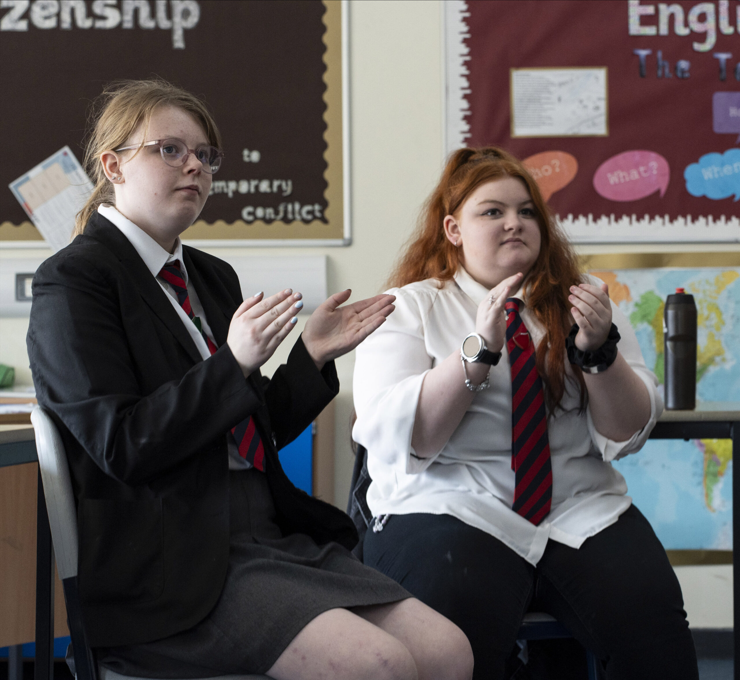 Two learners clap in a classroom
