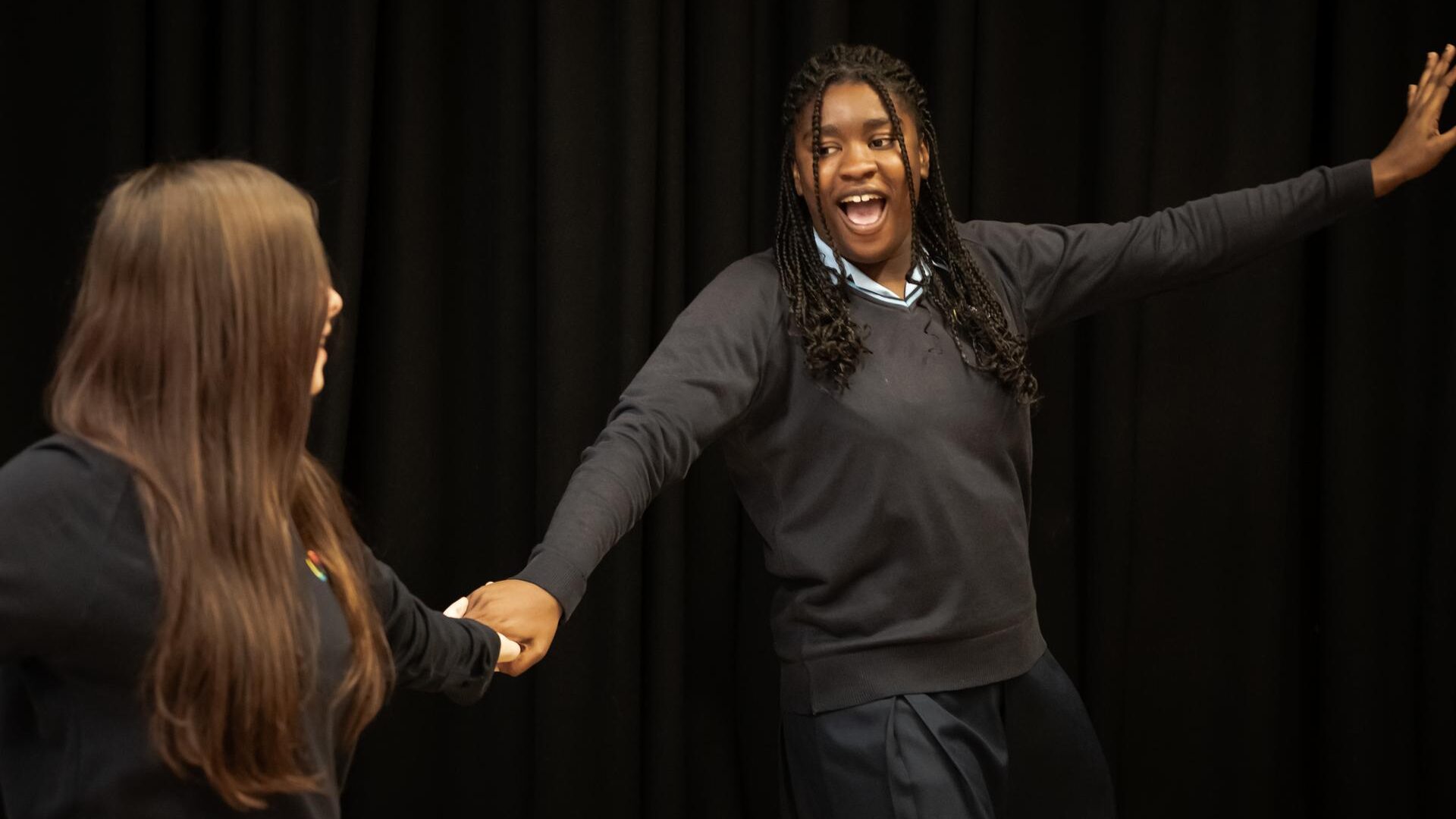 Two learners hold hands during a lesson