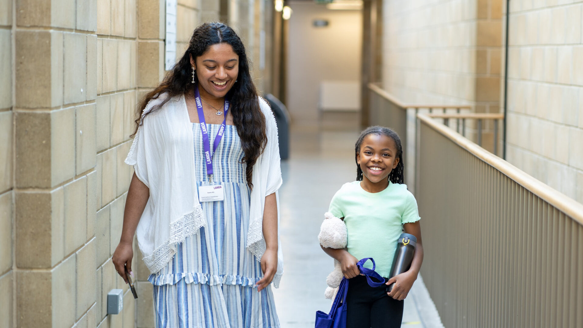 A learner and steward walk down the corridor