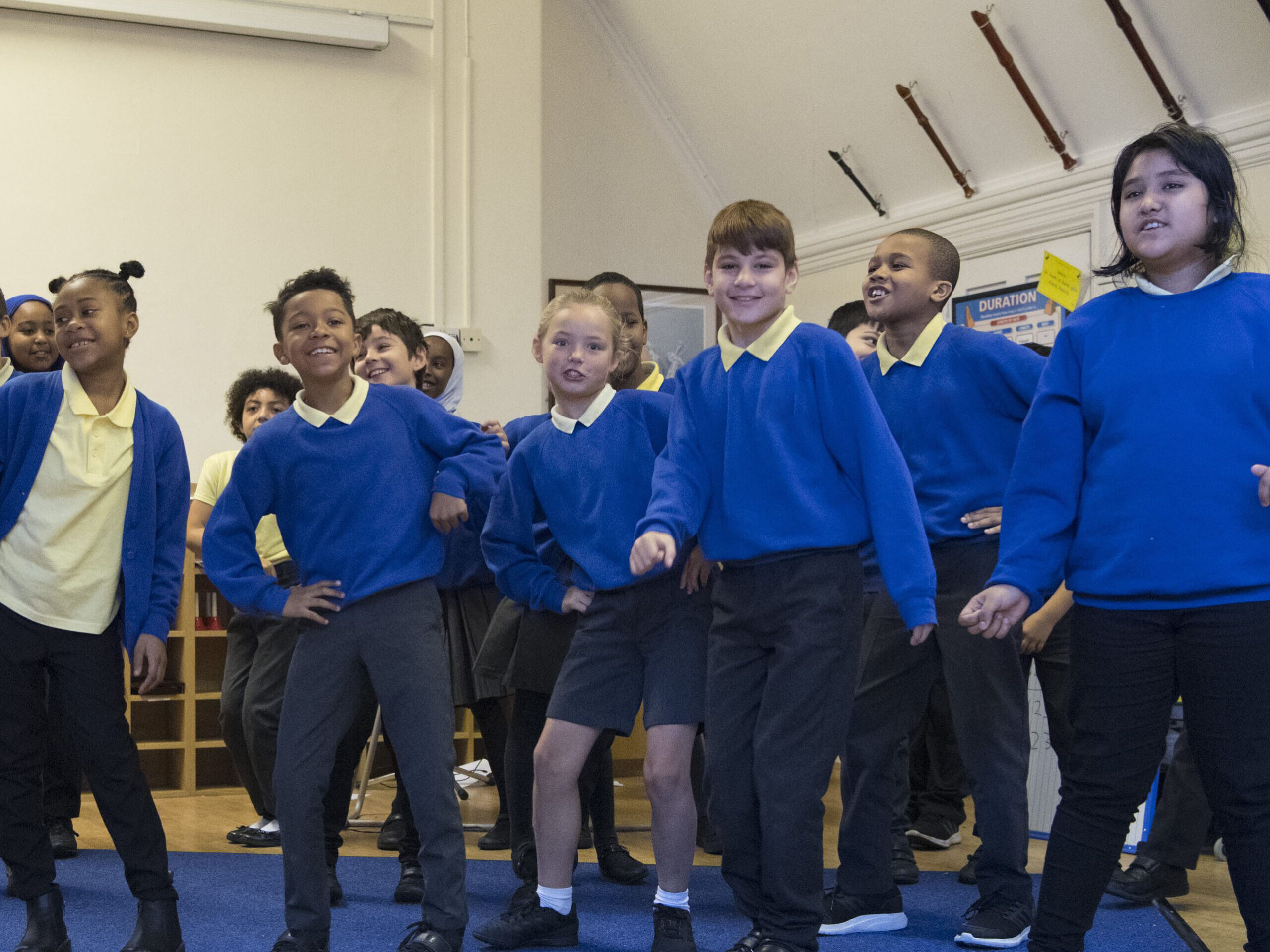 A group of learner sing in a classroom