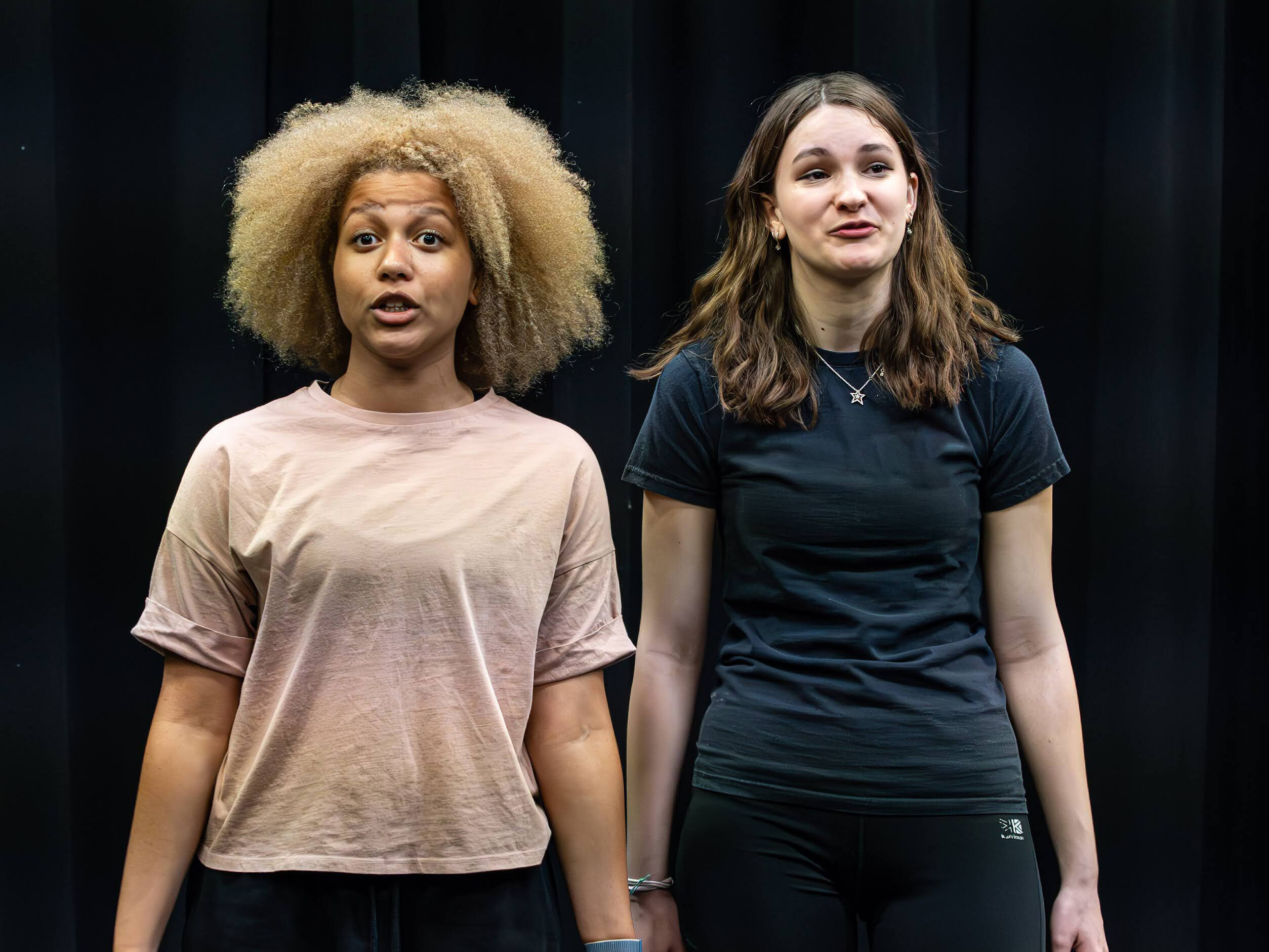 Two learners stand on a stage to perform