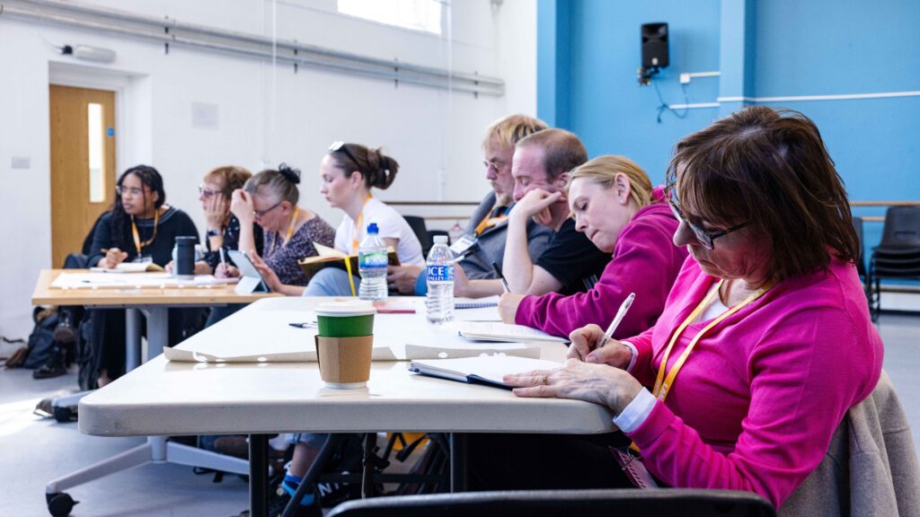 A group of teachers sit in a course