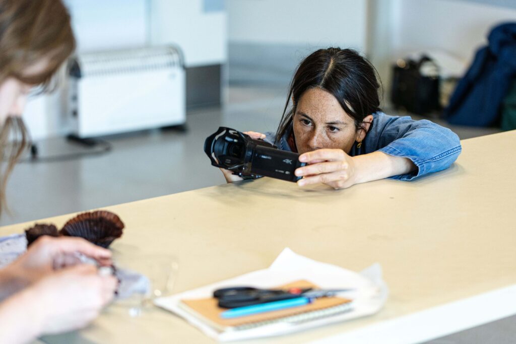 A screen acting class, with a teacher holding a camera pointed at a student
