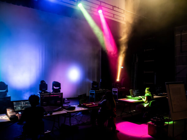 A stage area lit up by pink, blue and yellow lights