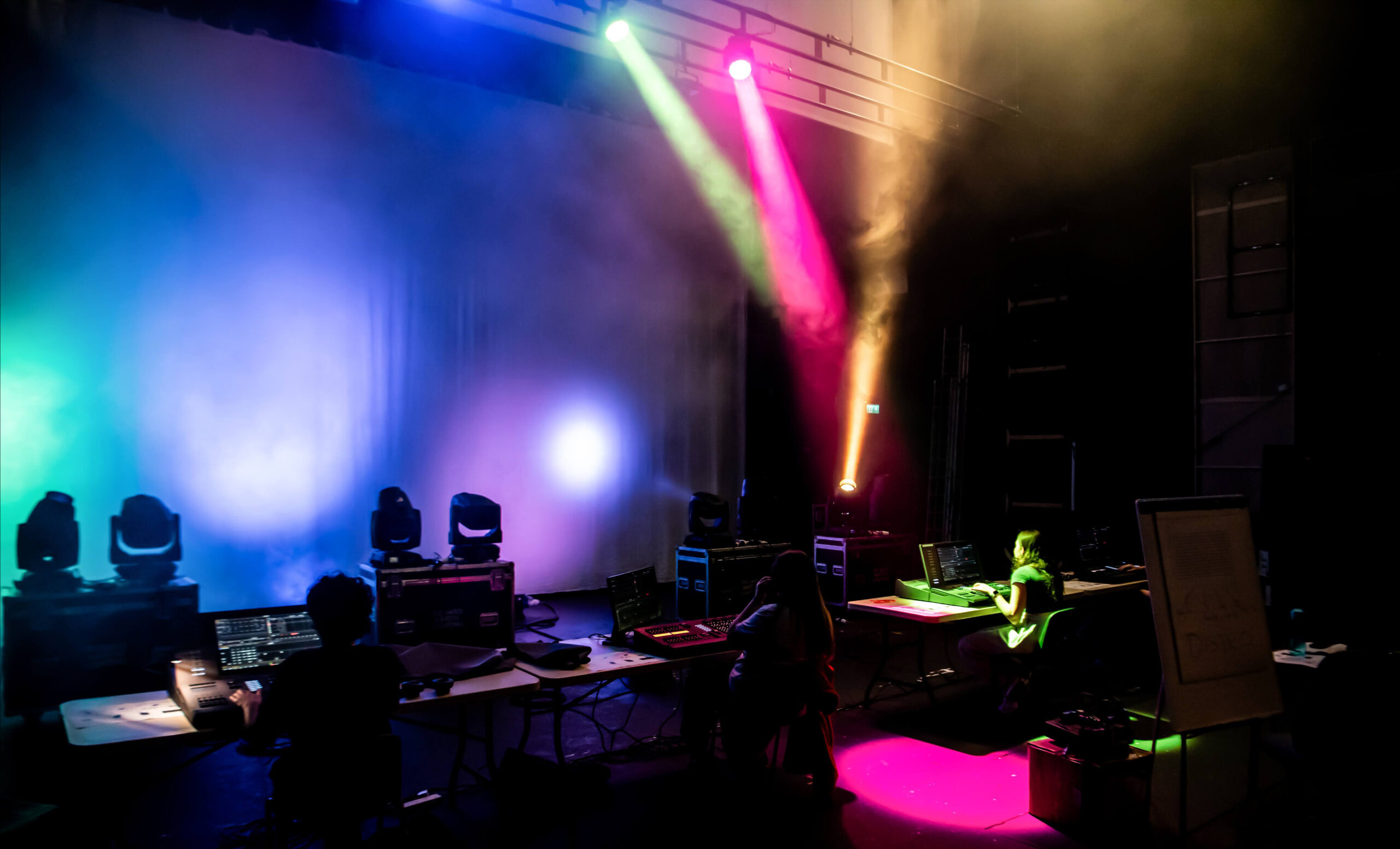 A stage area lit up by pink, blue and yellow lights